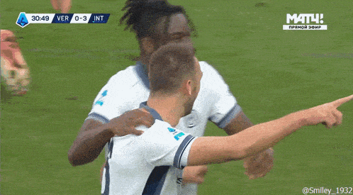 a group of soccer players are giving each other a high five in front of a screen that says match