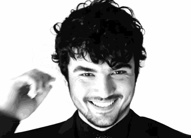 a black and white photo of a man with curly hair and a beard