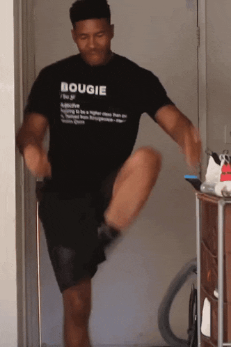 a man wearing a bougie t-shirt is doing a workout