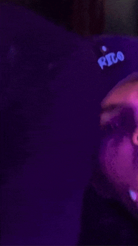 a person is wearing a purple shirt with a blue logo on the front