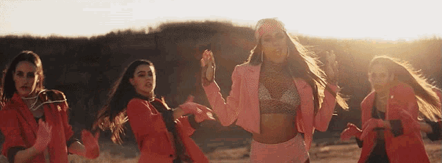 a woman in a pink jacket is surrounded by other women in red jackets