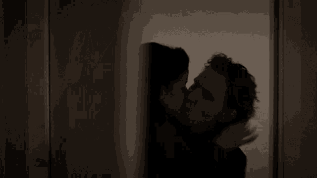 a woman standing in a dark room with a sign on the wall that says a