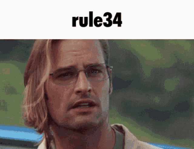 a man wearing glasses is looking at the camera with rule34 written on the bottom
