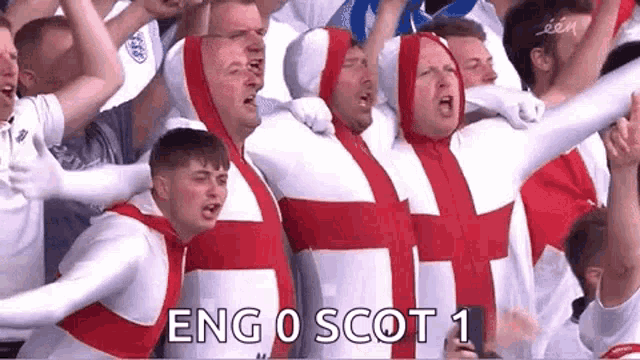 a group of men dressed as the british flag are standing in a stadium .