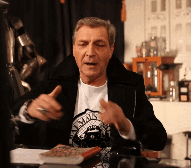 a man wearing a black jacket and a white shirt that says man on it