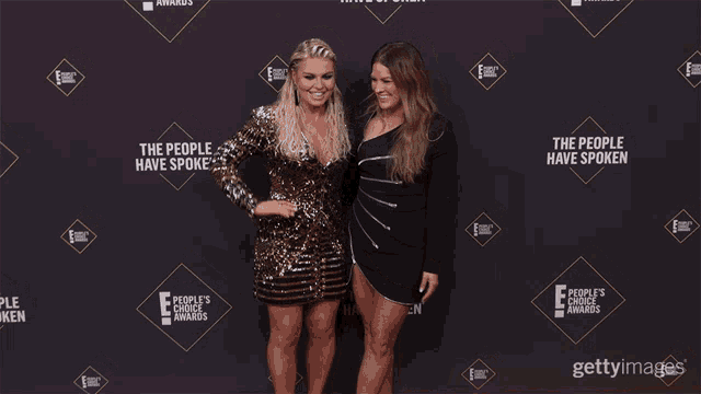 two women are standing on a red carpet with the words the people have spoken behind them