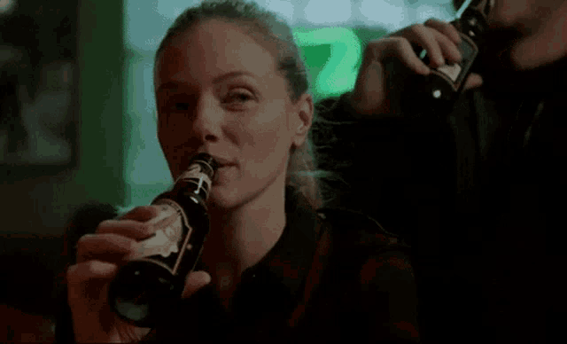 a woman drinking from a bottle with a label that says ' eagle '