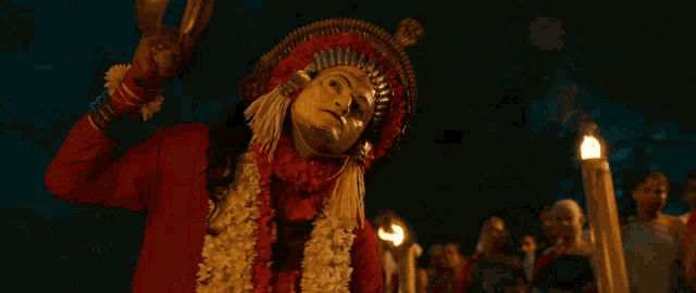 a man in a red and yellow costume holds a torch