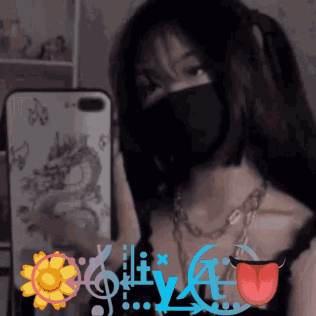 a girl wearing a mask is taking a picture of herself in front of a phone case with a dragon on it