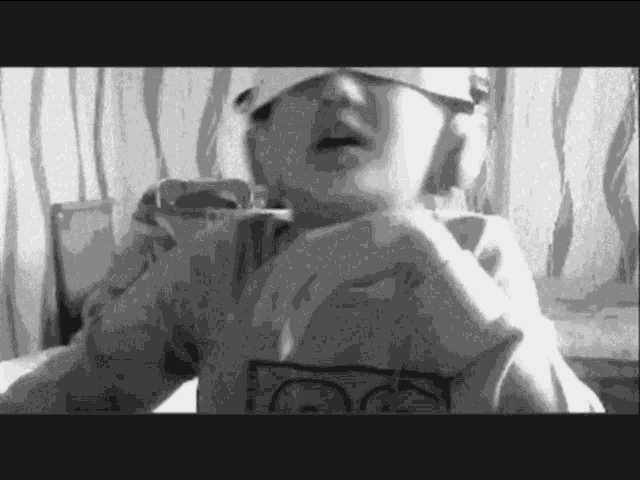 a black and white photo of a child wearing a hat