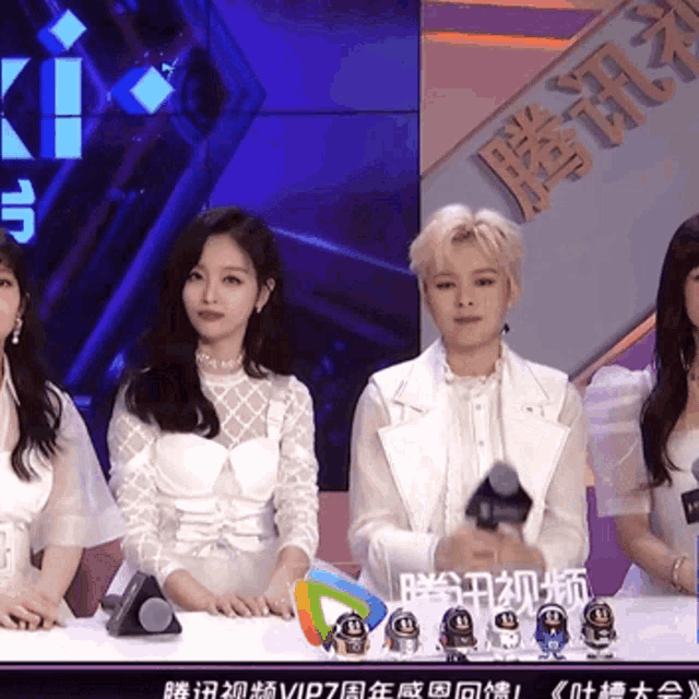 a group of women sit at a table in front of a sign that says ' vip7 ' on it