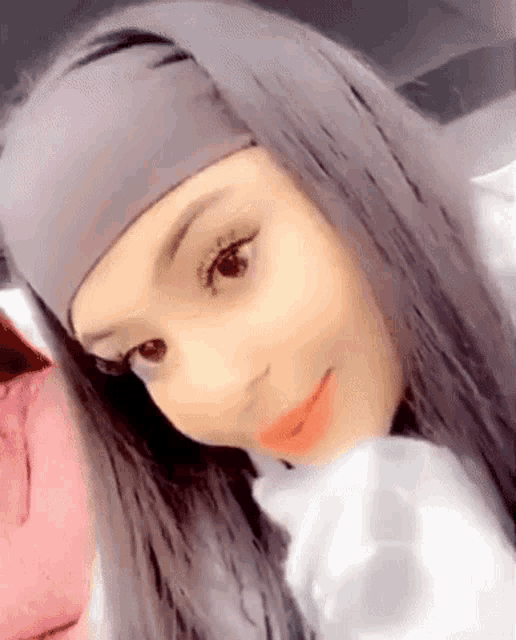 a girl with long hair and a headband on her head is smiling .