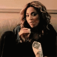 a woman is sitting on a couch eating a bag of chips and making a funny face .