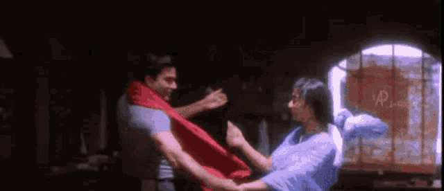 a man and a woman are holding hands and dancing in a room .
