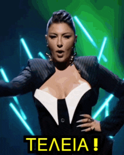 a woman with a very large breast is standing in front of a neon sign that says teleia .