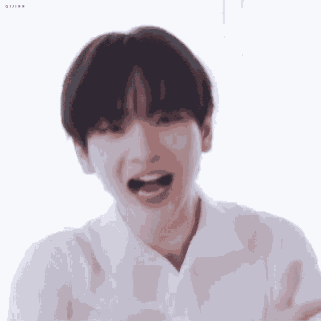 a young man in a white shirt is making a funny face