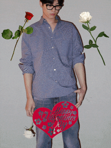 a man holds a red heart that says happy valentines day