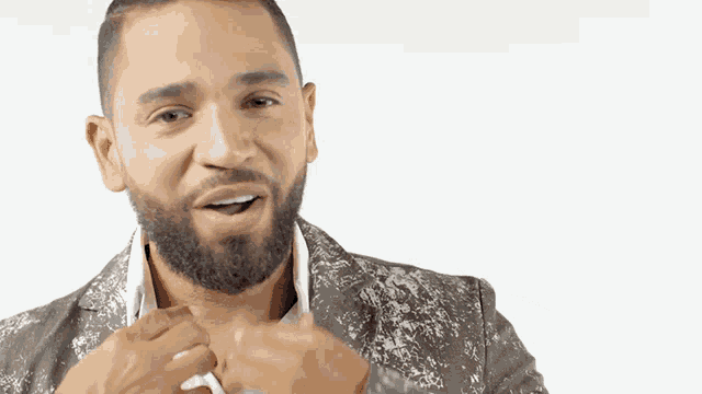 a man with a beard is adjusting his jacket collar