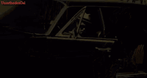 a man wearing sunglasses and a hat is standing next to a car with the words bruno mars on the bottom right