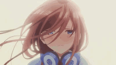 a close up of a girl wearing headphones and a hoodie .