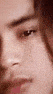 a close up of a person 's face with a blurred background .