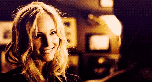 a woman is smiling and looking at the camera