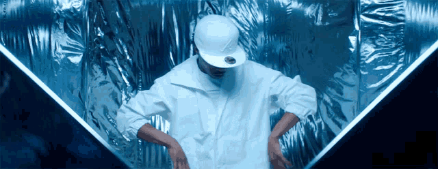 a man wearing a white hat and white jacket is dancing