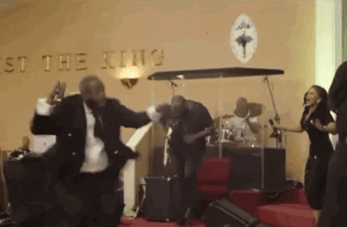 a group of people are dancing in front of a sign that says st. the king