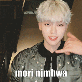 a young man with white hair is wearing a green jacket and a black tie and says mori nimhwa