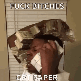 a man is holding a stack of money on his head while talking on a cell phone .