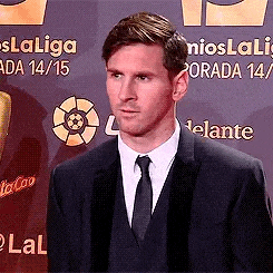 a man in a suit and tie is standing in front of a sign that says laliga .