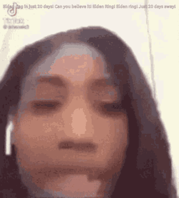 a close up of a woman 's face with a blurred background .