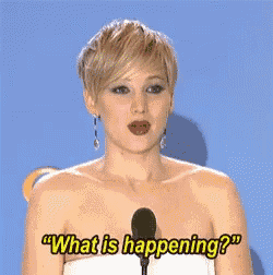 a woman in a white dress is talking into a microphone and saying what is happening .