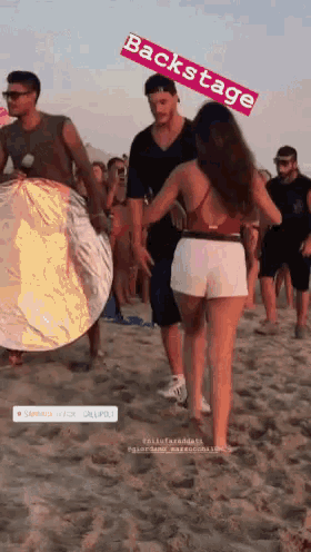 a group of people standing on a beach with the words backstage written above them