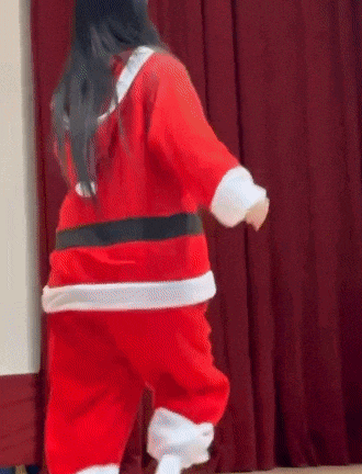a person in a santa claus costume is dancing on a stage .