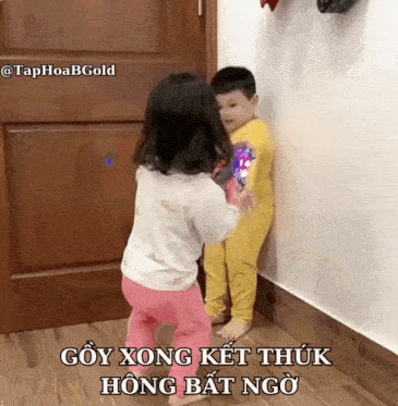 a little girl standing next to a little boy with a caption that says " goy xong kết thuk hong bat ngo "