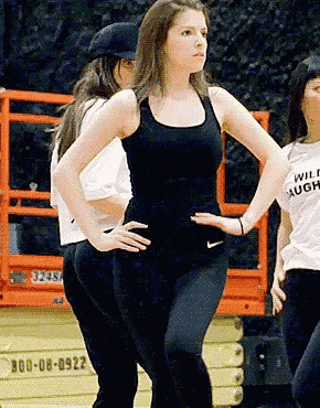 a woman with her hands on her hips is wearing a white shirt that says wild laugh