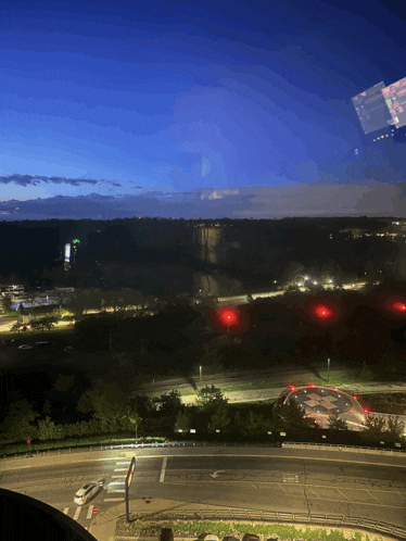 an aerial view of a city at night with a helicopter in the foreground