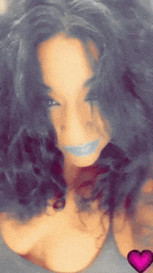 a close up of a woman 's face with a pink heart in the background