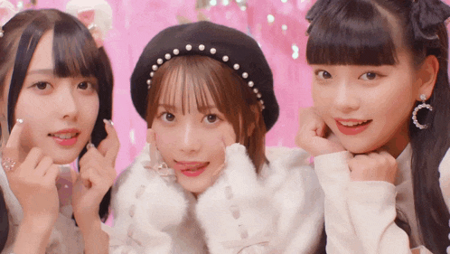 three girls are posing for a picture with one wearing a headband with pearls on it