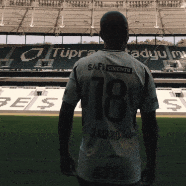 a man in a number 78 jersey stands in front of a stadium