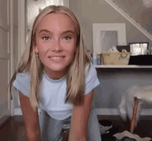 a young blonde woman in a white shirt and blue skirt is smiling
