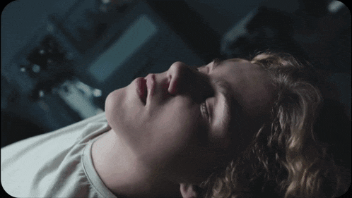 a close up of a young man laying down with his eyes closed