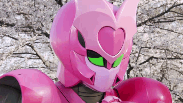 a pink robot with green eyes and a heart shaped head