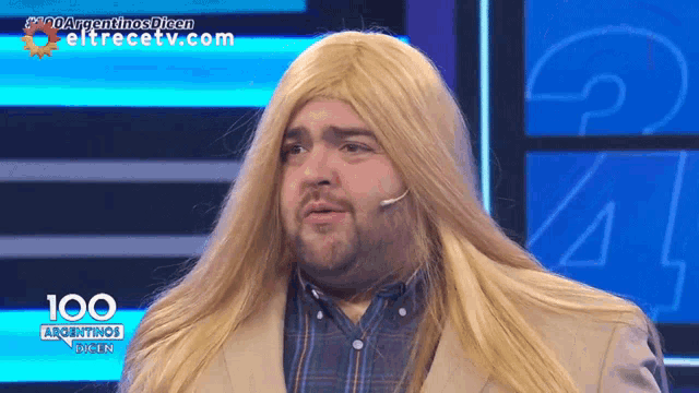 a man with long blonde hair and a microphone on a screen that says argentinas