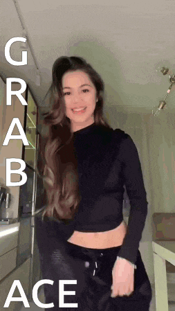 a woman in a black crop top is dancing in a kitchen with the words grab ace on the bottom