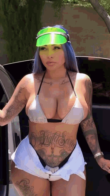 a woman in a bikini is standing next to a car .