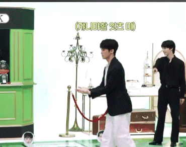 a man in a black suit is standing in front of a green counter with a sign that says ' k ' on it