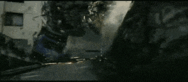 a robot is standing in front of a building that is burning