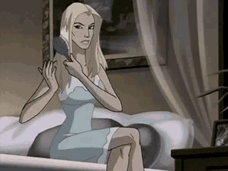 a woman in a blue dress is brushing her hair while sitting on a bed .